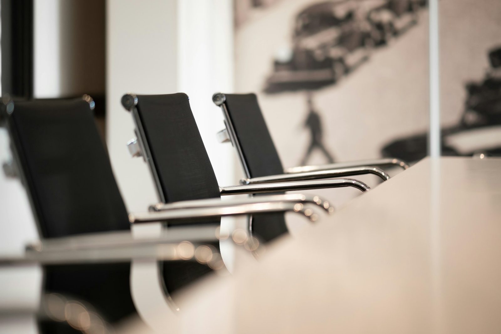 A row of empty chairs along a boardroom table.