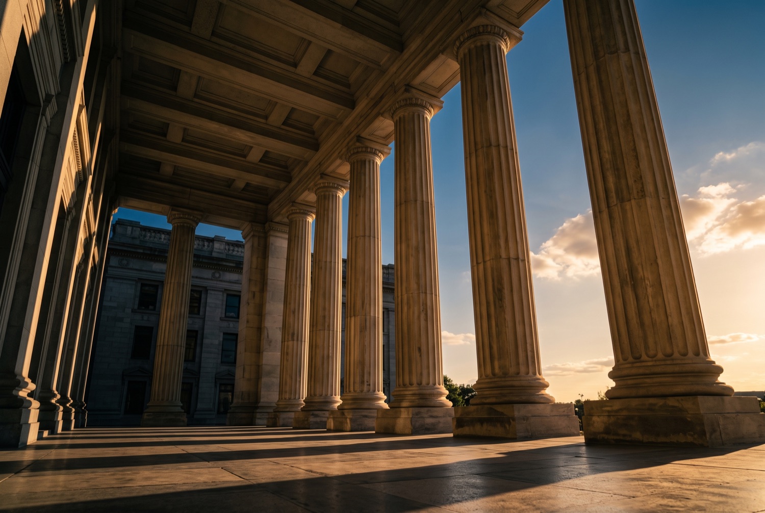 The colonnade of a county courthouse at golden hour.