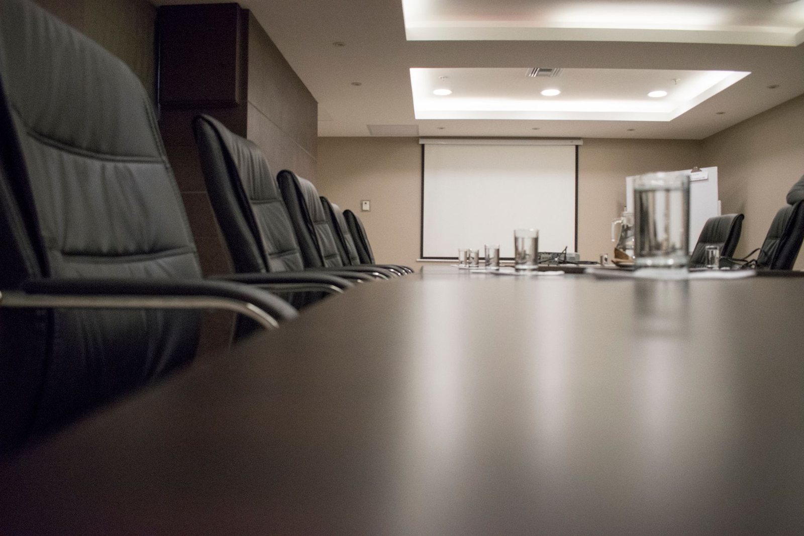 An empty boardroom table and chairs in a corporate office.
